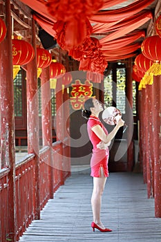 Happy Chinese bride in red cheongsam at traditional wedding day