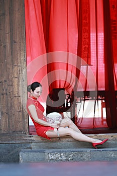 Happy Chinese bride in red cheongsam at traditional wedding day