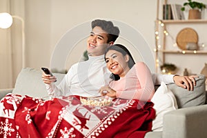 Happy Chinese Couple Watching TV On Christmas Eve At Home