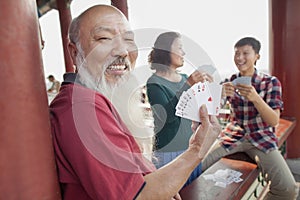 Happy Chinese Family Playing Card In Jing Shan Park, Showing Cards photo
