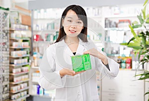 Happy chinese female pharmacist demonstrating assortment of pharmacy