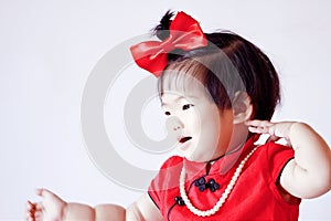 Happy Chinese little baby in red cheongsam have fun