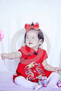 Happy Chinese little baby in red cheongsam have fun