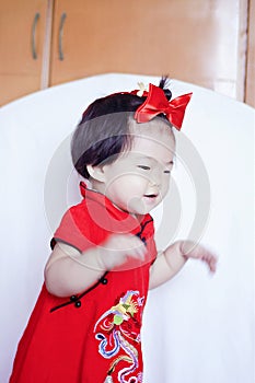 Happy Chinese little baby in red cheongsam have fun