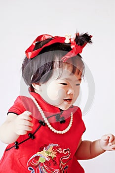 Happy Chinese little baby in red cheongsam have fun