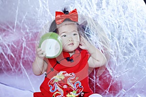 Happy Chinese little baby in red cheongsam have fun