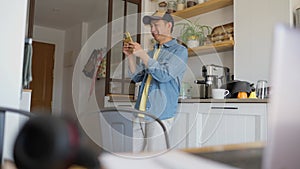 Happy chinese man using mobile at home