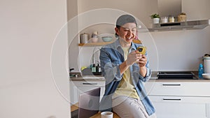 Happy chinese man using the mobile in the kitchen