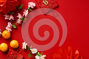 Happy Chinese New Year 2023 year of the rabbit. Flat lay red envelope packets, orange mandarins, Chinese blossom flowers and