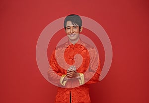 Happy Chinese new year 2024. portrait Asian man happy smile wearing red traditional clothing isolated on red background