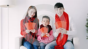 happy chinese new year. asian family showing red envelope for celebrating chinese new year