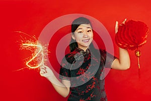 Happy Chinese New Year. Asian young girls`s portrait isolated on red background