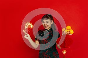 Happy Chinese New Year. Asian young girls`s portrait isolated on red background