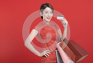Happy chinese new year. Asian young Woman showing credit card  and holding  the shopping bags
