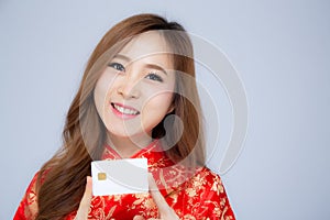 Happy Chinese New Year beautiful portrait young asian woman holding credit card present showing shopping online