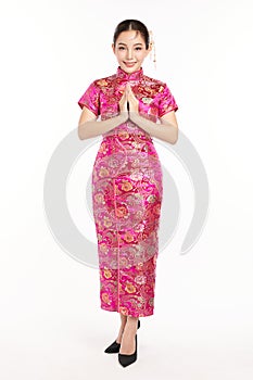 Happy Chinese new year, Beautiful young Asian woman wearing traditional cheongsam qipao dress with gesture of congratulation