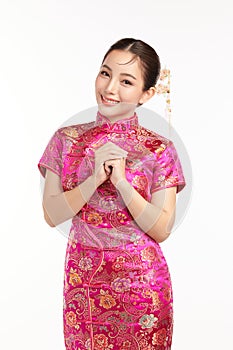 Happy Chinese new year, Beautiful young Asian woman wearing traditional cheongsam qipao dress with gesture of congratulation