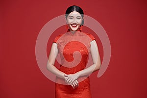 Happy Chinese new year. portrait beautiful asian woman wearing traditional qipao dress  on red background