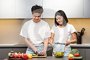 Happy Chinese Spouses Cooking Together In Kitchen At Home