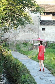Happy Chinese woman in red cheongsam tour at ancient town