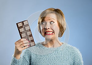 Happy chocolate addict woman holding big bar mouth stained and crazy excited face expression