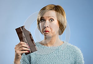 Happy chocolate addict woman holding big bar mouth stained and crazy excited face expression