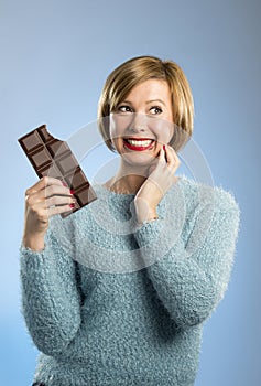 Happy chocolate addict woman holding big bar mouth stained and crazy excited face expression