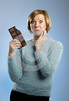 Happy chocolate addict woman holding big bar mouth stained and crazy excited face expression