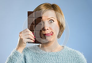 Happy chocolate addict woman holding big bar mouth stained and crazy excited face expression