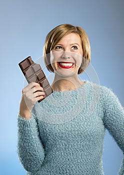 Happy chocolate addict woman holding big bar mouth stained and crazy excited face expression