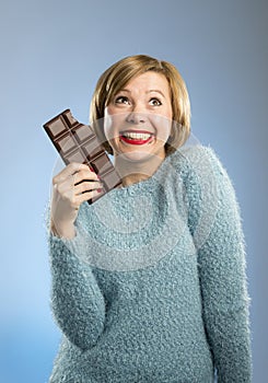 Happy chocolate addict woman holding big bar mouth stained and crazy excited face expression