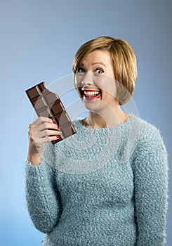 Happy chocolate addict woman holding big bar mouth stained and crazy excited face expression