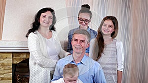 Happy christian family of five posing together for family portrait, first photosession of child