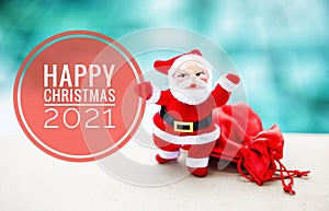 Happy Christmas banner with Santa claus with red bag over blurred blue water background