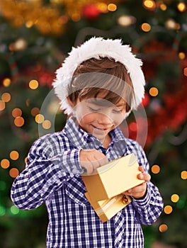 Happy, Christmas and boy child with present for celebration or surprise at festive party at home. Smile, santa hat and