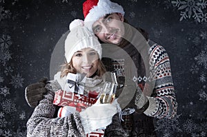 Happy Christmas couple with glasses and gifts