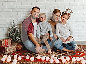 Happy Christmas! family mother father and kids   before Christmas with garland   and tree