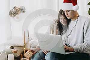 Happy christmas family shopping online or video call on laptop in room with xmas presents and decor