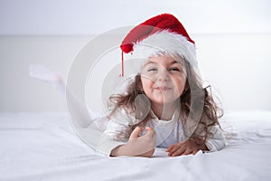 Happy Christmas time, little girl in Santa Claus hat smilling