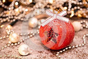 Happy Christmas time. A pomegranate and Christmas decoration in warm colors