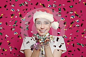 Happy Christmas woman with confetti against vivid pink background