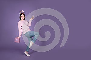 Happy Christmas woman having fun with gift on purple banner background