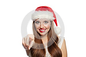 Happy Christmas woman in Santa hat pointing isolated on white background