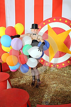 Happy circus actress in black hat with colored photo
