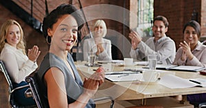 Happy, clapping hands and winning business team celebrating their success in a boardroom. Portrait of a diverse group of