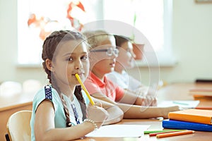 Happy clever children learning in classroom