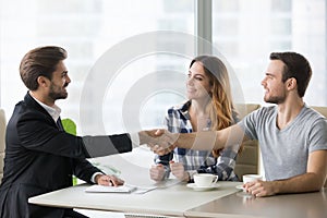 Happy clients couple handshake lawyer thanking for help