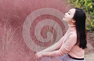 Happy closed eyes Asian Chinese woman girl feel freedom sweet dream pray flower field autumn fall park grass lawn hope nature