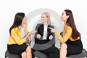 Happy colleagues women sitting in office talking with each other.