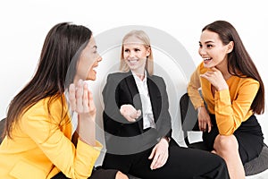 Happy colleagues women sitting in office talking with each other.